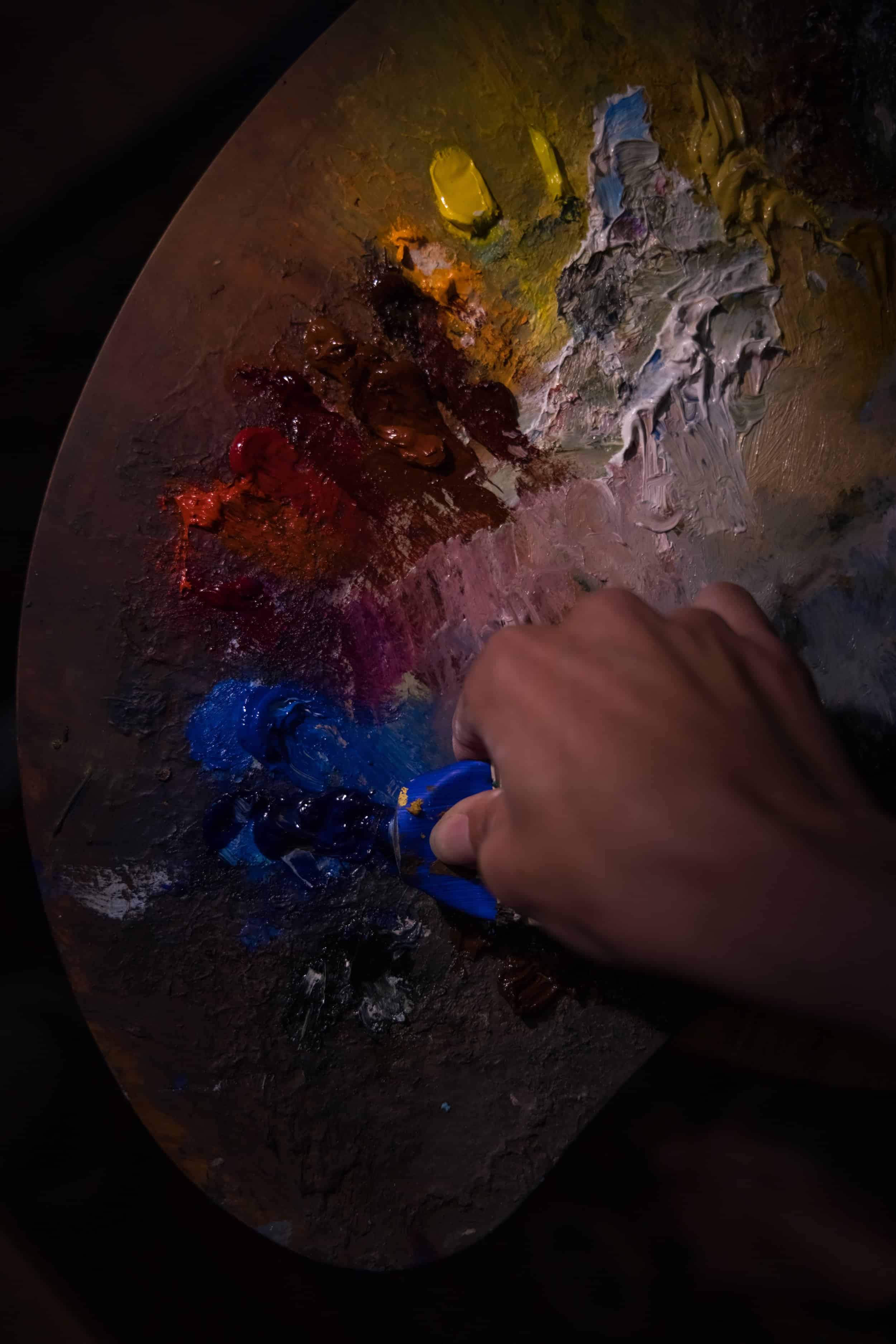 Hand squeezing paint onto palette
