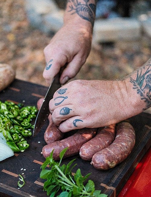 Jesse Griffiths preparing food on cutting board